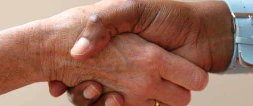 Helping hand shakes another in an agreement